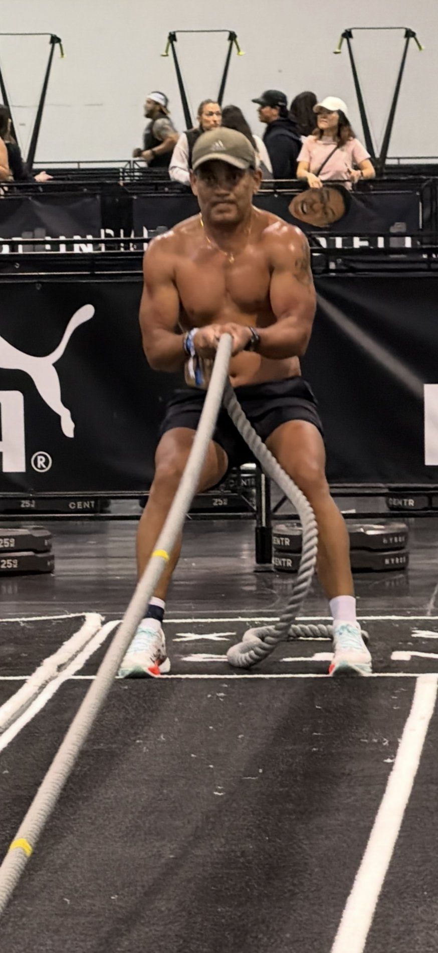 Akash pulling battle ropes on the Hyrox competition floor.